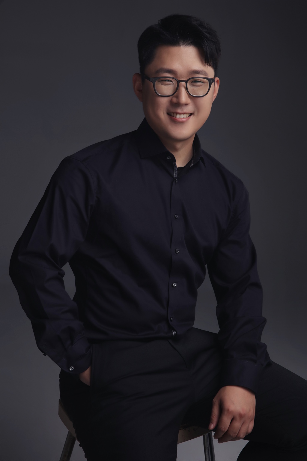 Soohyeon Kim sitzt lächelnd auf einem Hocker